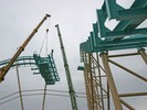 Maar liefst twee kranen zijn er nodig om het loodzware draaiplateau een 30 meter de lucht in te tillen.